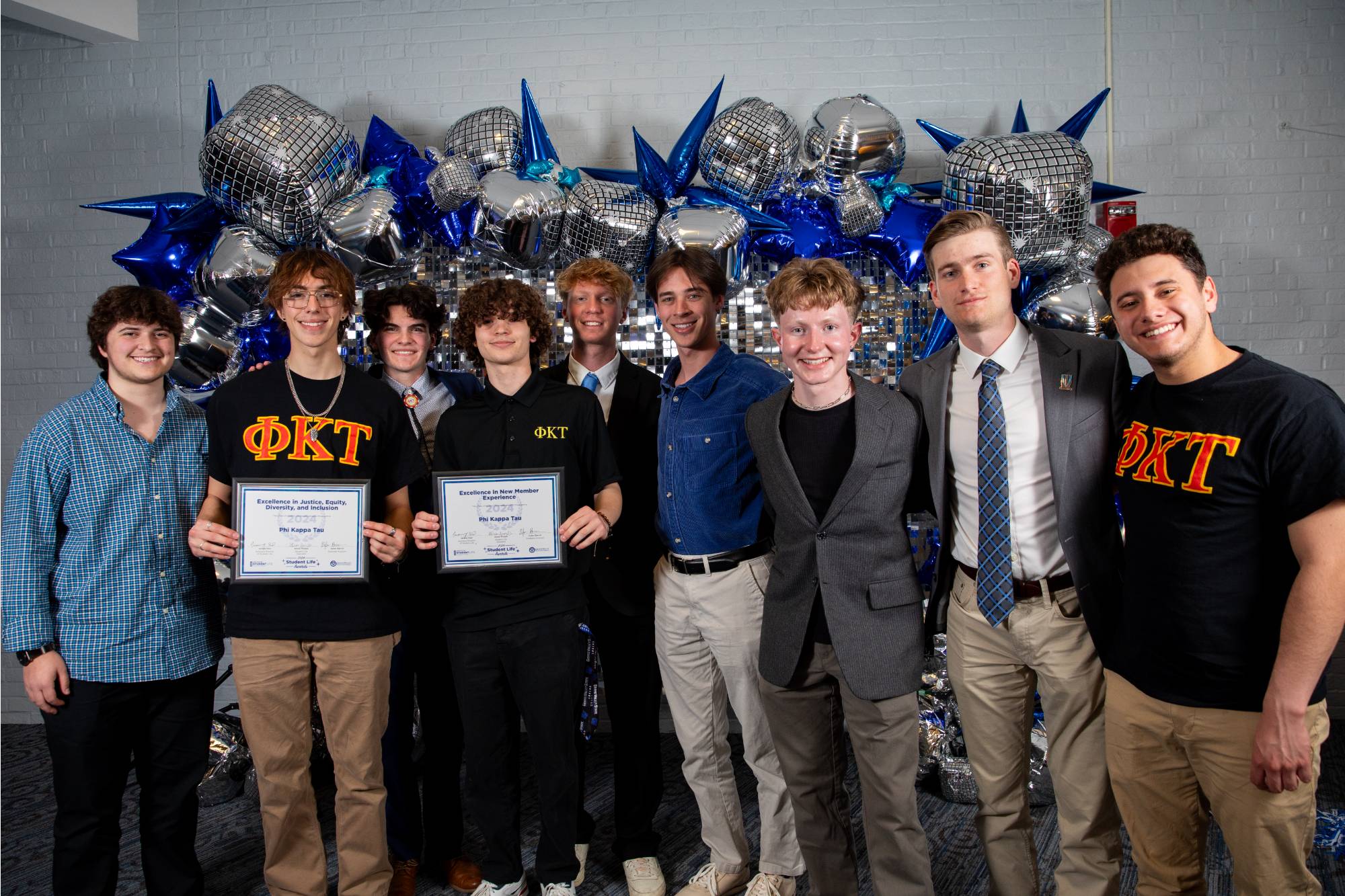 Greek students smiling at the camera and holding a certificate